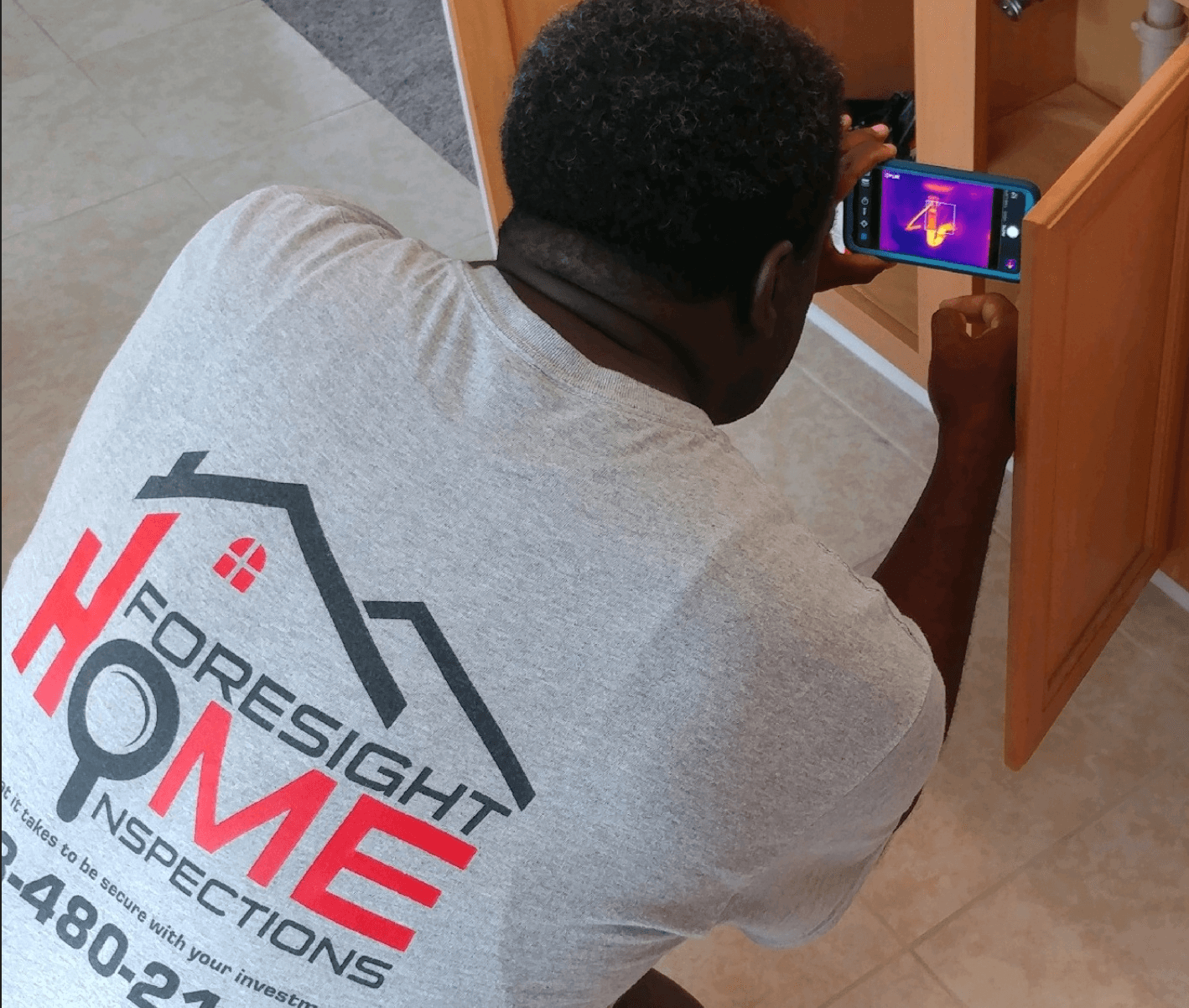 Infrared Thermal Imaging (FLIR) camera inspecting home electrical heat profile in Between